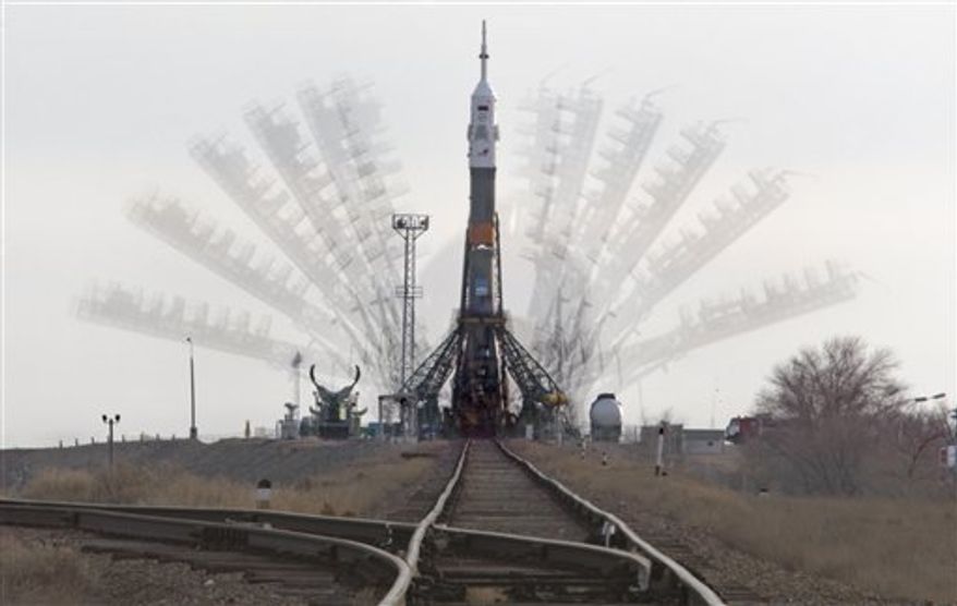 Service towers lift up to the Russian Soyuz TMA-20 space ship that will carry new crew to the International Space Station, ISS, on the launch pad at the Russian leased Baikonur cosmodrome, Kazakhstan, Monday, Dec. 13, 2010. The start of the new Soyuz mission is scheduled for Wednesday. (AP Photo/Dmitry Lovetsky)