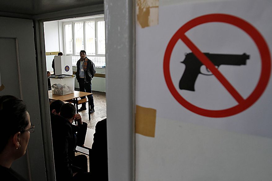 People vote at a polling station in general elections in Kosovo's capital Pristina on Sunday, Dec. 12, 2010. Kosovars vote in the first general poll since the country's declaration of independence from Serbia in 2008, a critical election already marred by ethnic tension that many fear will split the world's newest country.(AP Photo/Visar Kryeziu)