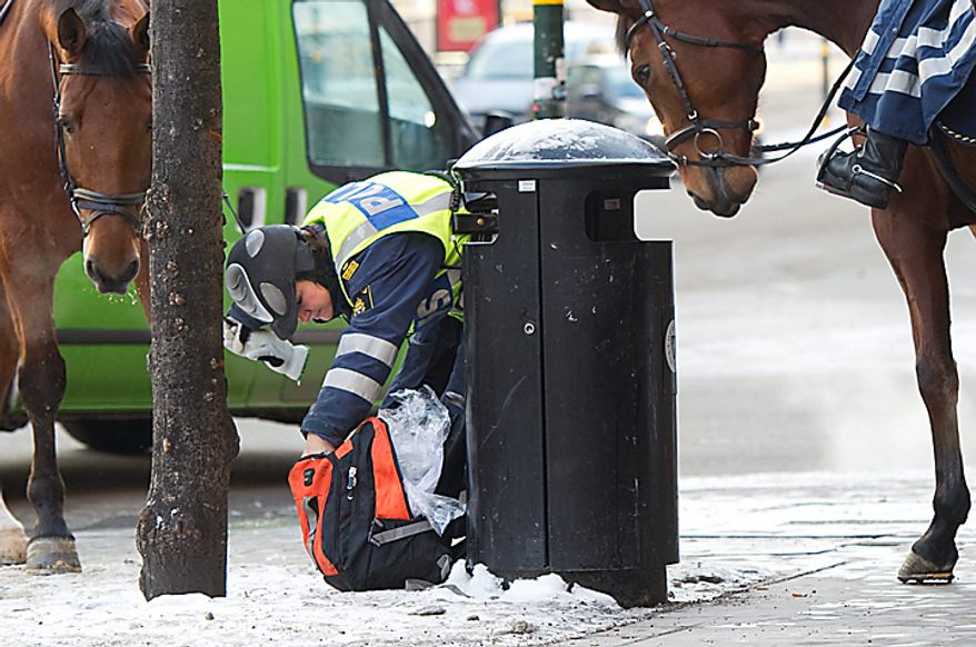 Mounted police officers check a bag in Stockholm Monday Dec. 13, 2010 security has been stepped up in the Swedish capital after Saturdays suicide bomb attack.(AP Photo/ Fredrik Sandberg)