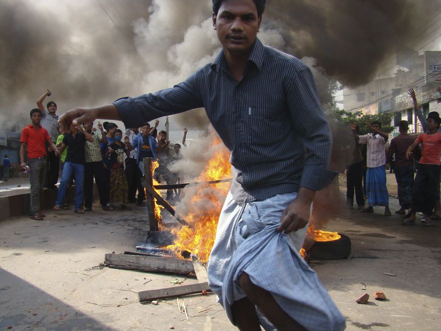 Protesting Bangladeshi garments workers burn tires and furniture to block traffic, at Chittagong, 135 miles southeast of Dhaka, Bangladesh, Sunday, Dec. 12, 2010. Garment workers demanding the implementation of a new minimum wage clashed with police at an industrial zone in southeastern Bangladesh on Sunday, leaving up to three people dead and 100 hurt, police and news reports said. (AP Photo/ Alauddin Hossain Dulall)