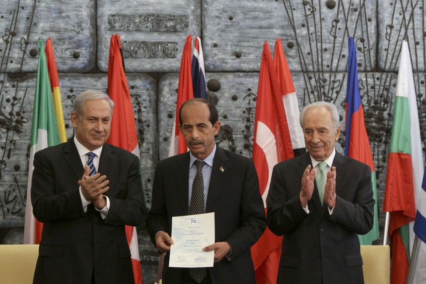 Israeli Prime Minister Benjamin Netanyahu, left, and Israeli President Shimon Peres, right, stand with a representative of the Palestinian Authority, name not known, as he accepts a certificate of appreciation and award for Palestinian help in fighting the wildfires at the Carmel forest in northern Israel, during a ceremony in Jerusalem, Tuesday, Dec. 7, 2010. Another ceremony to honor the Palestinian firefighters was canceled Tuesday, Dec. 14, 2010, when most of the Palestinians did not get their permits to enter Israel. (AP Photo/Tara Todras-Whitehill)