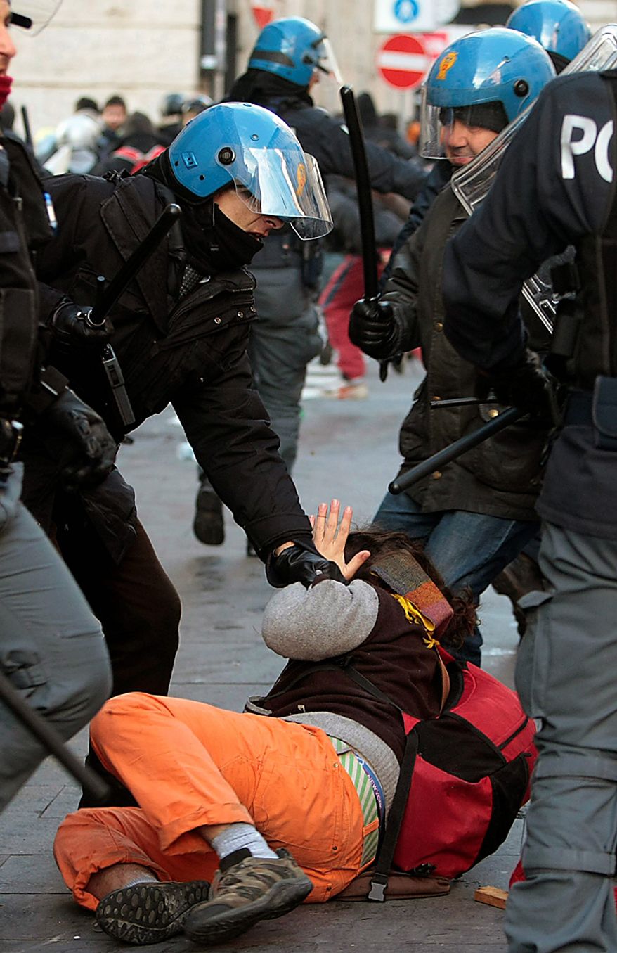 Police subdue a demonstrator during clashes in Rome, Tuesday, Dec. 14, 2010. Outside parliament, thousands of students, some of them downing beers as they marched, smashed shop windows, destroyed bank ATMs and set at least three vehicles on fire. At one point they even entered a bank, prompting staffers to try to barricade themselves inside. Police fired tear gas as the protesters neared Prime Minister Silvio Berlusconi's residence. (AP Photo/Gregorio Borgia)