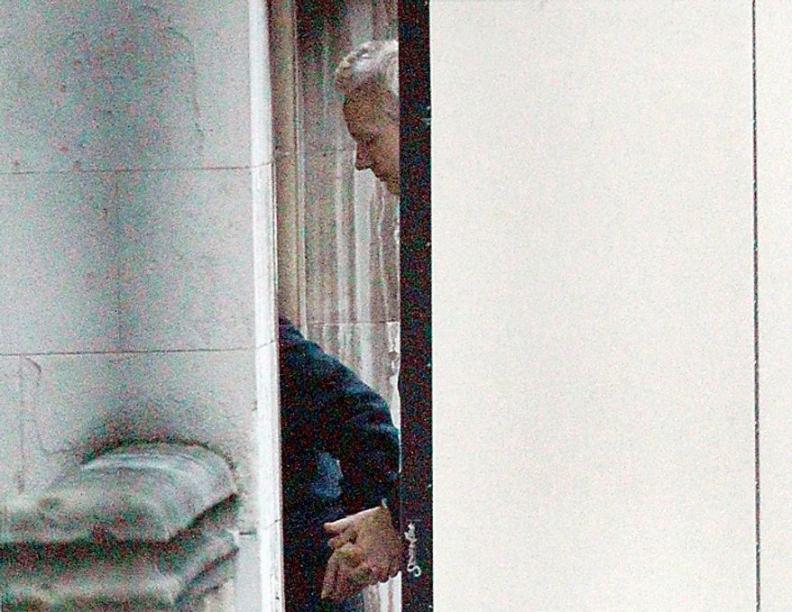 The founder of WikiLeaks Julian Assange is screened from public view as he arrives at the High Court in London, Thursday, Dec. 16, 2010. Assange will be freed on bail and sent to stay at a British country mansion, a judge ruled Thursday, rejecting prosecutors' attempts to keep the WikiLeaks founder in prison as he fights extradition to Sweden. (AP Photo/Matt Dunham)
