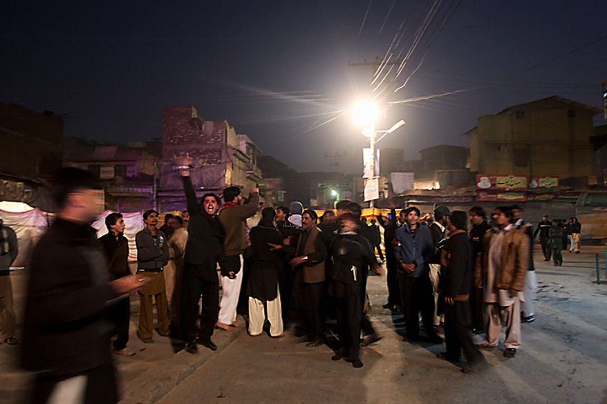 Shi'ite Muslims chant anti-government slogans at the site of an explosion in Peshawar, Pakistan, on Thursday, Dec. 16, 2010. An assailant threw an explosive device at Shi'ite Muslims carrying out a Muharram procession in the city, wounding several people. (AP Photo/Mohammad Sajjad)