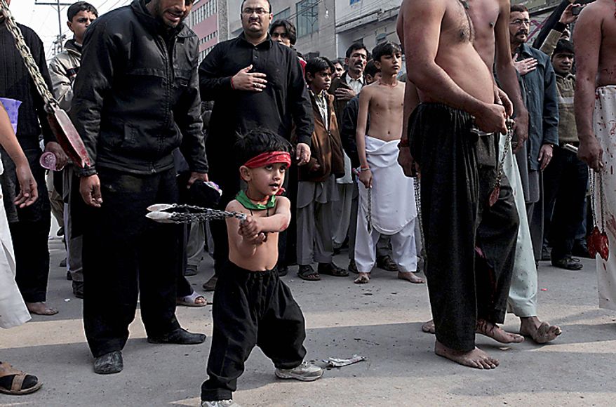 A Shi'ite Muslim child beats himself with bladed chains during a Muharram procession in Peshawar, Pakistan, on Thursday, Dec. 16, 2010. Muharram is observed around the world for ten days as mourning in remembrance of the martyrdom of Imam Hussein, the grandson of Prophet Muhammad. (AP Photo/Mohammad Sajjad)