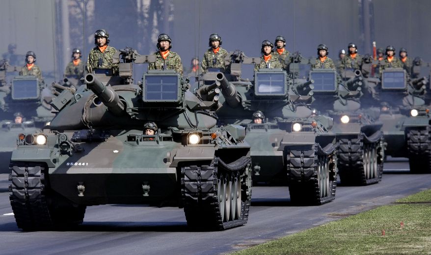 In this Oct. 28, 2007, file photo, Japan Ground Self-Defense Force tanks rumble during a military parade, marking the 57th anniversary of the founding of the Japan Self-Defense Forces at Asaka Base, north of Tokyo. Japan should refocus its defense strategy on the rise of China and not on the Cold War threat of Russia, according to new guidelines announced Friday Dec. 17, 2010. (AP Photo/Itsuo Inouye, File)