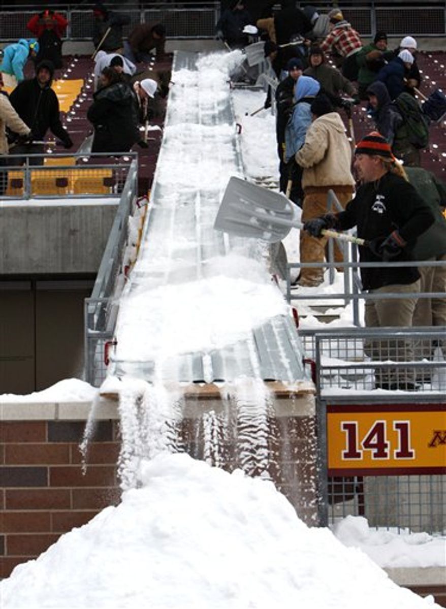 Workers are shown beneath the snow-damaged roof inside the Metrodome in Minneapolis, Friday, Dec. 17, 2010. (AP Photo/The Star Tribune, Elizabeth Flores)
