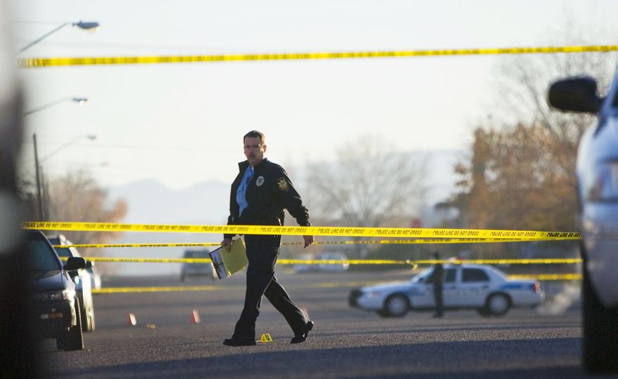 A police officer works a crime scene in St. George, Utah, on Saturday, Dec. 11, 2010. (AP Photo/The Spectrum, Samantha Clemens)