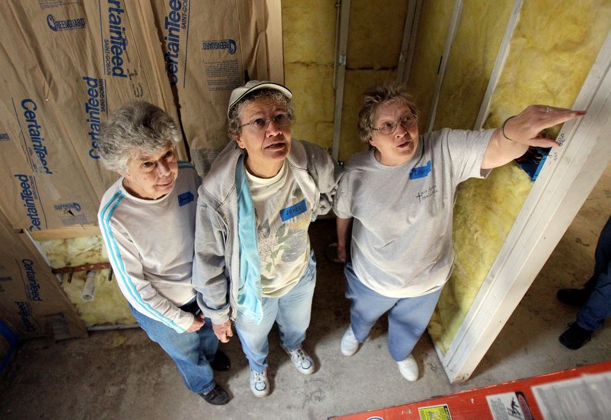 Associated Press photographs
From left, Catholic Sisters Gracie Whittaker, Joyce Richter and Louise Smith examine a ceiling while rebuilding a Hurricane Katrina-damaged house in New Orleans on Nov. 19. Nuns from all over the country have taken part in the Nuns Build project.