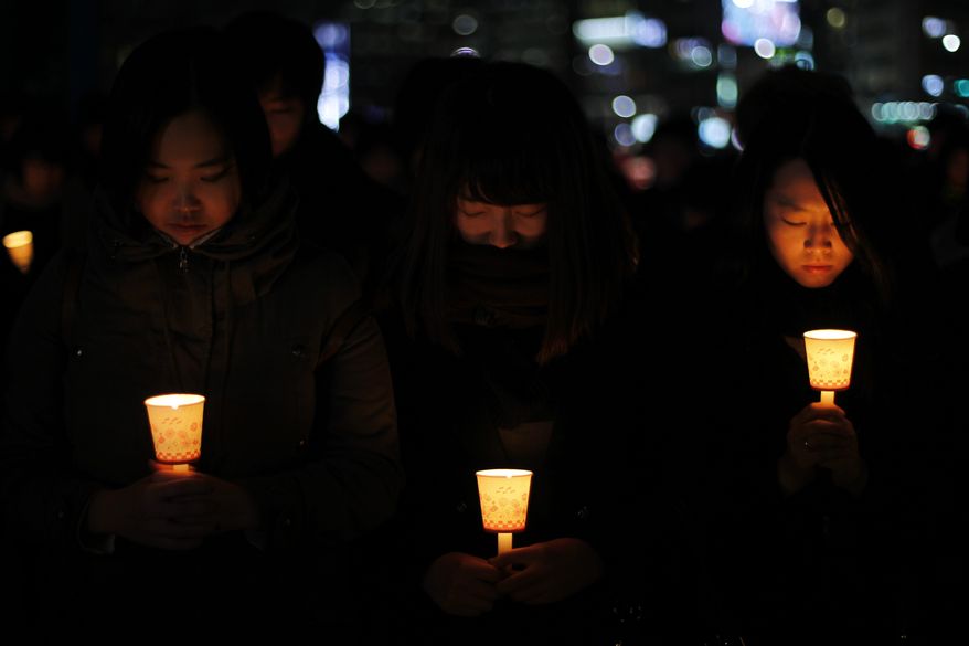 South Korean girls take part in a candlelight vigil in downtown Seoul on Wednesday, Dec. 22, 2010, the eve of the one-month anniversary of the attack on Yeonpyeong Island. (AP Photo/Ng Han Guan)