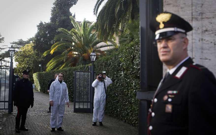 Forensic officers of the Carabinieri inspect the area inside the Swiss Embassy compound in Rome, where a package exploded on Thursday, Dec. 23, 2010. (AP Photo/Angelo Carconi)