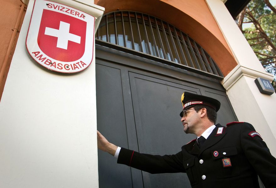 A Carabinieri paramilitary police officer rings the bell at the entrance of the Swiss Embassy in Rome on Thursday, Dec. 23, 2010, where a package exploded and wounded an embassy staffer, police said. (AP Photo/Angelo Carconi)