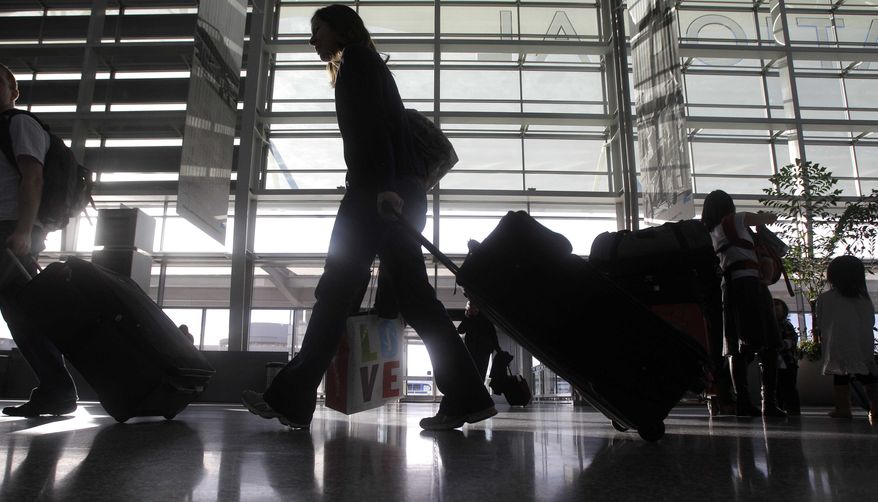 ** FILE ** A woman pulls her travel bag in the International terminal at San Francisco International Airport in San Francisco on Thursday, Dec. 23, 2010. (AP Photo/Jeff Chiu