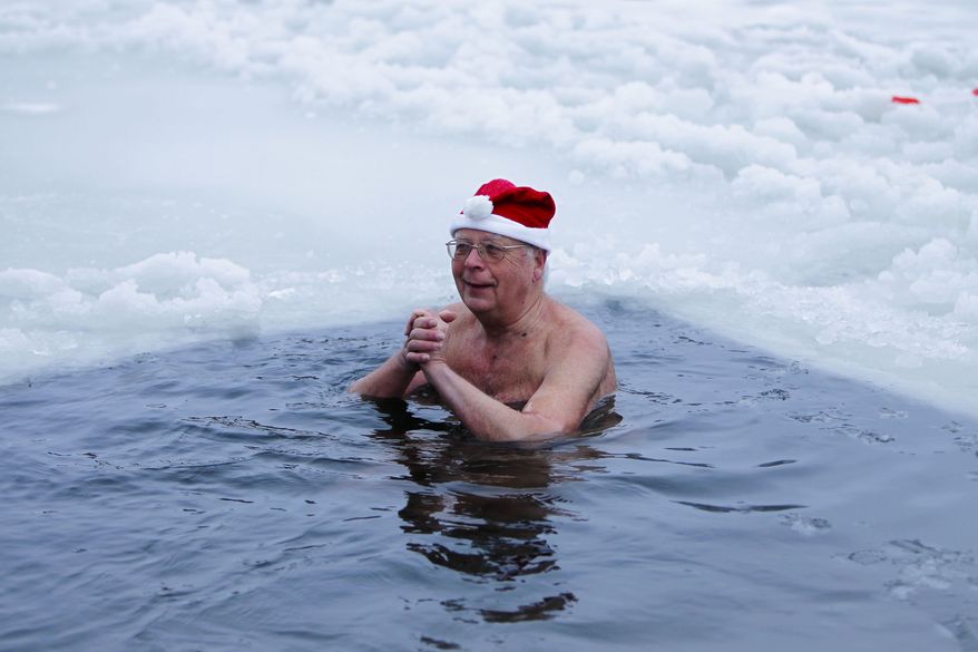 A member of the Seehunde Berlin, or Berlin Seals, swimming club takes a dip in the frozen Orankesee lake in Berlin on Saturday, Dec. 25, 2010. Every Christmas, the club arranges a holiday swimming session in the lake. (AP Photo/Markus Schreiber)