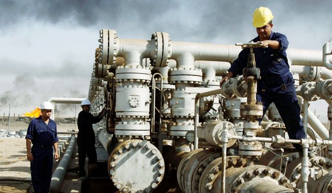**FILE** Iraqis work at the Rumaila oil refinery near the city of Basra. The province, located on the Persian Gulf bordering Kuwait and Iran, is Iraq&#x27;s only outlet to the sea and is the hub for most of Iraq&#x27;s oil exports of nearly 1.9 million barrels a day to the international market. (Associated Press)