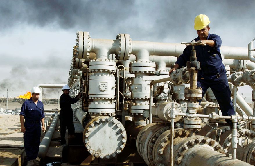**FILE** Iraqis work at the Rumaila oil refinery near the city of Basra. The province, located on the Persian Gulf bordering Kuwait and Iran, is Iraq's only outlet to the sea and is the hub for most of Iraq's oil exports of nearly 1.9 million barrels a day to the international market. (Associated Press)