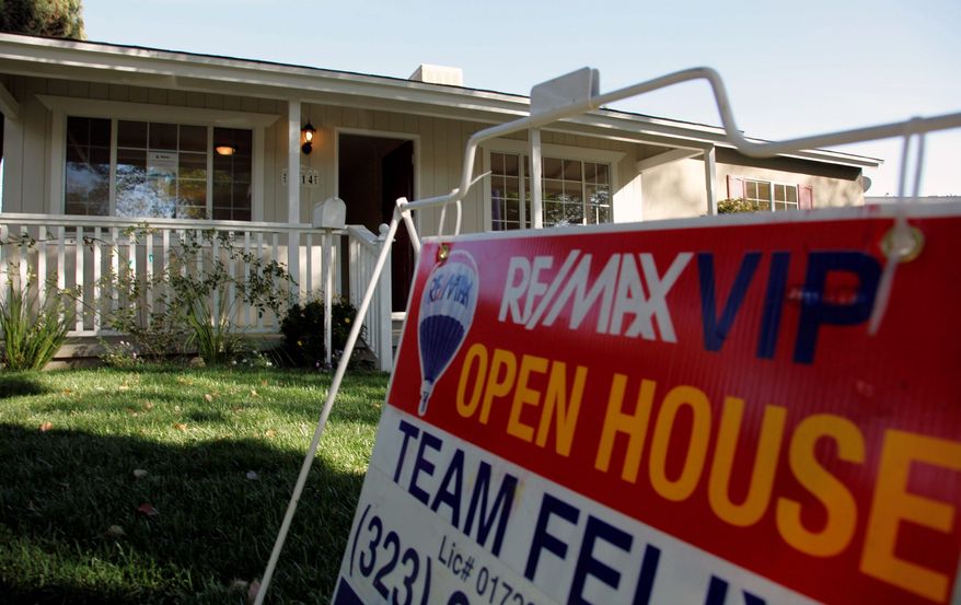 An "open house" sign is seen on the front lawn of a home for sale in Los Angeles. Home prices are dropping in the nation's largest cities and are expected to fall through next year, with the worst declines coming in areas with high numbers of foreclosures. (Associated Press)