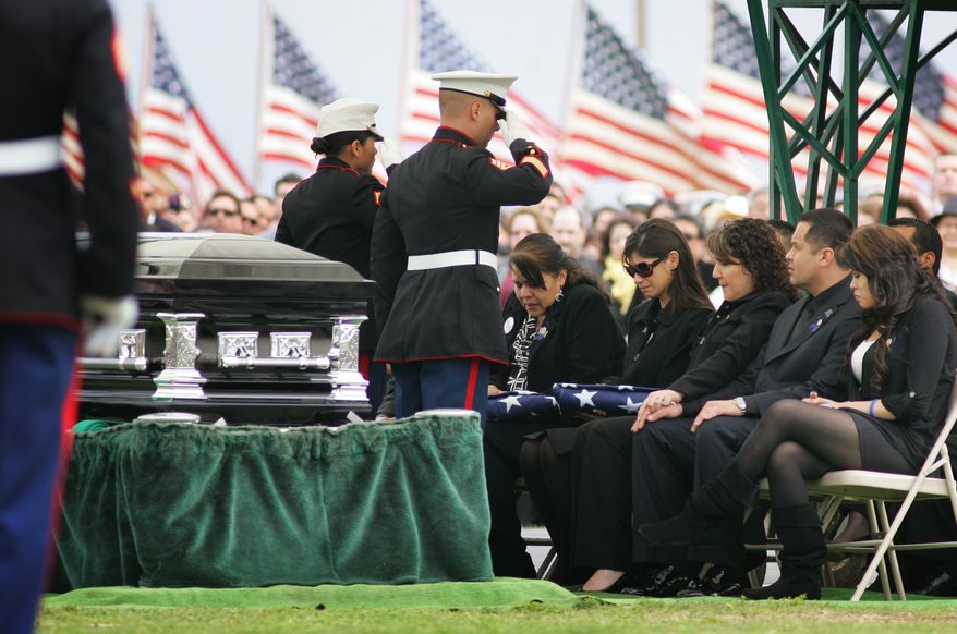 ** FILE ** Marines salute Saloma Bejar and Mariam Bejar, the mother and wife, respectively, of fallen police Officer Javier Bejar, after presenting the ceremonial flag at services in Reedley, Calif., in March 2010. (AP Photo/Gary Kazanjian, File)