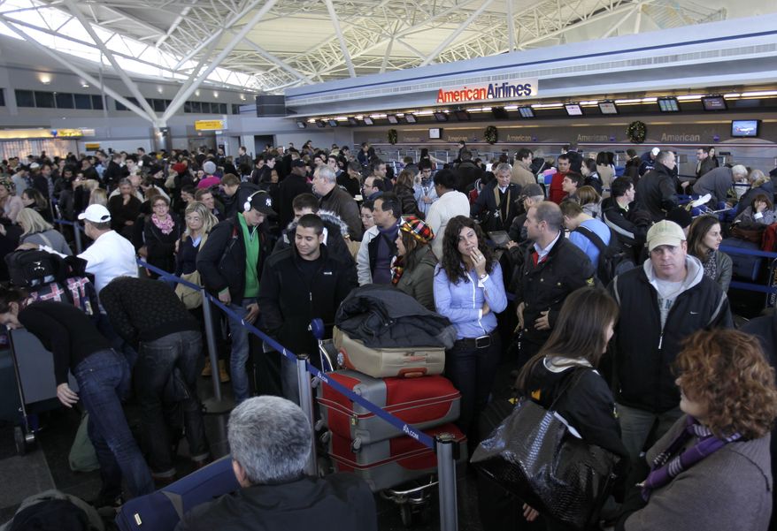 Travelers wait in line to find out the status of their flights at John F. Kennedy International Airport in New York on Monday, Dec. 27, 2010. (AP Photo/Seth Wenig)