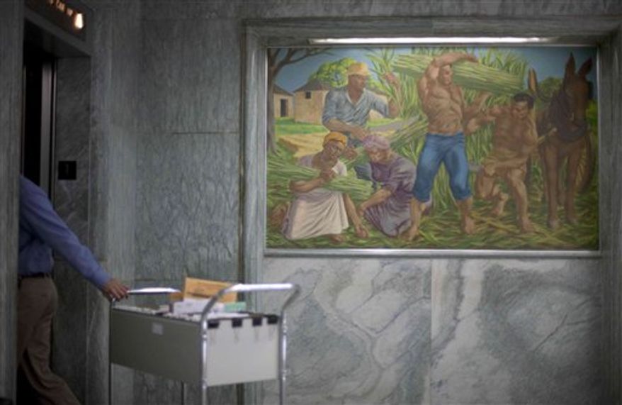 One of seven historic paintings hang in the lobby of the Georgia Department of Agriculture as a visitor checks into the security desk Tuesday, Dec. 28, 2010, in Atlanta. The incoming Georgia agriculture commissioner wants to remove the paintings including one depicting idealized versions of slavery and put them into storage when he takes office next month. Those pastel paintings have hung in the lobby of a state building for half a century without causing a stir. (AP Photo/David Goldman)