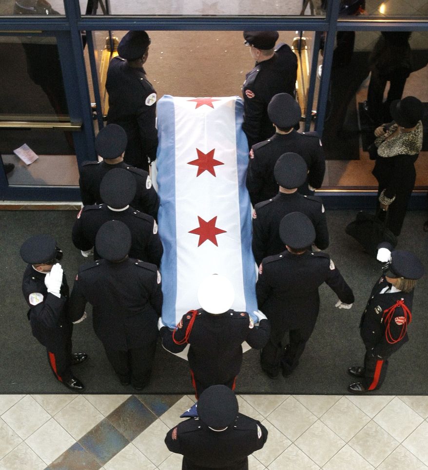 Chicago firefighters carry the casket containing the body of firefighter Corey Ankum to a fire truck after Dec. 30 funeral services in Chicago. Ankum was one of two firefighters killed last week when a roof collapsed after a fire. (Associated Press)