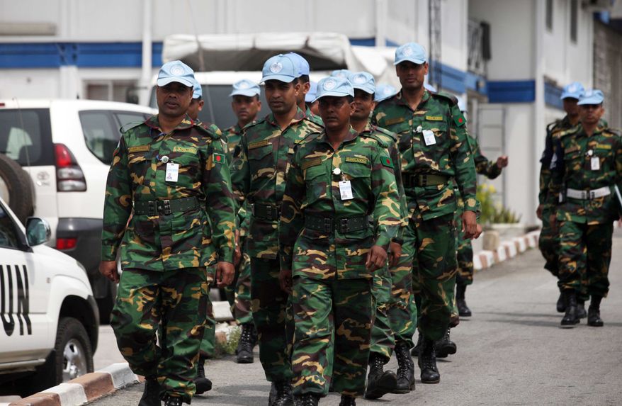 U.N. troops walk inside the U.N. Headquarters in Abidjan, Ivory Cost, on Friday, Dec. 31, 2010. The United Nations is warning supporters of incumbent leader Laurent Gbagbo that an attack on the hotel where the internationally recognized winner of last month's election is based could reignite civil war. (AP Photo/Sunday Alamba)