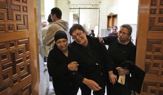 Ahlam Fawzy Saber (center), an Egyptian Coptic Christian who lost two of her sisters and a niece in an apparent suicide bombing during midnight Mass, is helped back into the Saints Church in Alexandria, Egypt, after collapsing from emotion following morning Mass on Sunday, Jan. 2, 2011. Grieving Christians, many clad in black, were back praying Sunday in the blood-spattered church, where 21 worshippers were killed in the blast. (AP Photo/Ben Curtis) ** FILE **