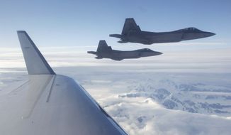 A pair of U.S.-built NORAD F-22 fighter jets fly off the wing of a civilian airplane playing the role of a hijacked airliner over a mountainous area of Alaska on Aug. 10, 2010, at the end of a route from an undisclosed location in the Far East to Alaska. The first-of-its-kind hijacking exercise involving the U.S., Canadian and Russian militaries went so well that a similar drill is planned for 2011. (AP Photo/Ted S. Warren, File) ** FILE **