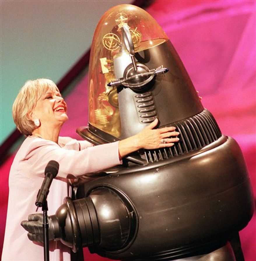 FILE - In a March 7, 1998 file photo, actors Anne Francis and Robbie the Robot, who both starred in the 1956 science fiction thriller "Forbidden Planet," share a hug, during the taping of an Easter Seals television special in Los Angeles. Francis, who was the love interest in the 1950s science-fiction classic "Forbidden Planet" and later was sexy private eye in "Honey West" on TV, has died at age 80. Francis died Sunday, Jan 2, 2011 at a Santa Barbara nursing home, said Bill Guntle, a funeral director McDermott-Crockett & Associates Mortuary in Santa Barbara. (AP Photo/John Hayes, File)