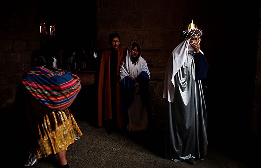 People dressed as one of the three kings (right) and Mary and Joseph (center) attend an Epiphany Mass at a Catholic church in La Paz, Bolivia, on Thursday Jan. 6, 2011. The feast day recalls the Gospel's account of the journey by the three kings, or wise men, guided by a star to pay homage to baby Jesus, and many faithful exchange gifts. (AP Photo/Juan Karita)