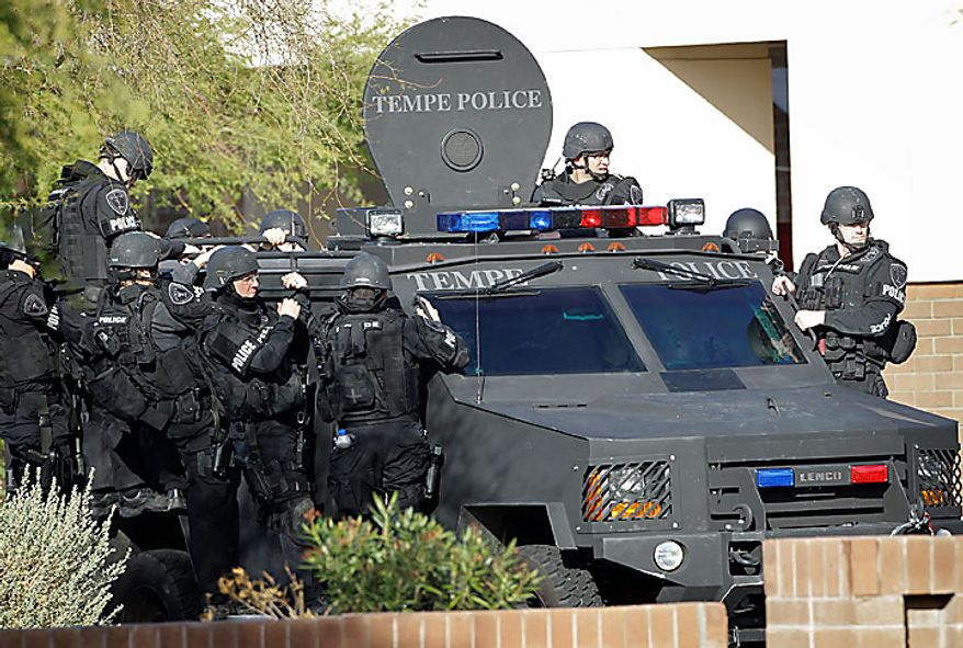 Law enforcement officials leave a Baja Fresh restaurant after a man surrendered to police Wednesday, Jan. 5, 2011 in Chandler, Ariz. Chandler police spokesman Sgt. Joe Favazzo says a gunman entered a Baja Fresh restaurant and fired a gun in what police think was a warning to customers following a shooting at the Chandler Mall. (AP Photo/Matt York)