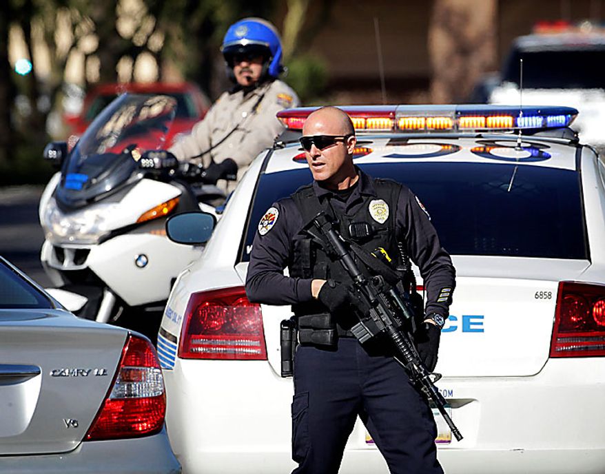 Law enforcement officials block the entrance to a Baja Fresh restaurant Wednesday, Jan. 5, 2011 in Chandler, Ariz. Chandler police spokesman Sgt. Joe Favazzo says a gunman entered a Baja Fresh restaurant and fired a gun in what police think was a warning to customers following a shooting at the Chandler Mall. (AP Photo/Matt York)