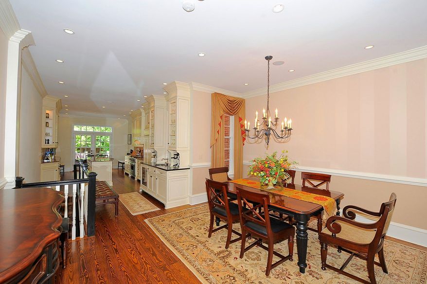 The formal dining room has a chandelier, faux-painted walls and pine flooring. A butler's pantry and wet bar with a granite counter separate the dining room and kitchen.