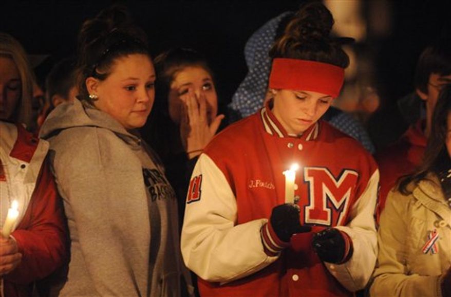 Millard South High School students hold a candle light vigil in front of the school Thursday Jan. 6, 2011, in Omaha, Neb. A student opened fire killing the assistant principal, and wounding the principal on Wednesday. (AP Photo/Dave Weaver)