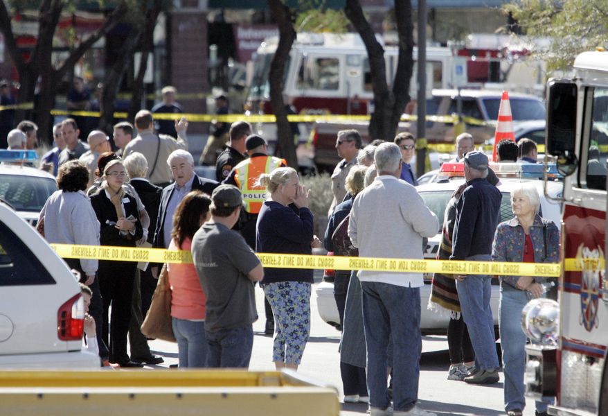 People gather at the scene of a shooting involving Rep. Gabrielle Giffords, D-Ariz., on Jan. 8, 2011, in Tucson, Ariz. (AP Photo/Arizona Daily Star, Dean Knuth)