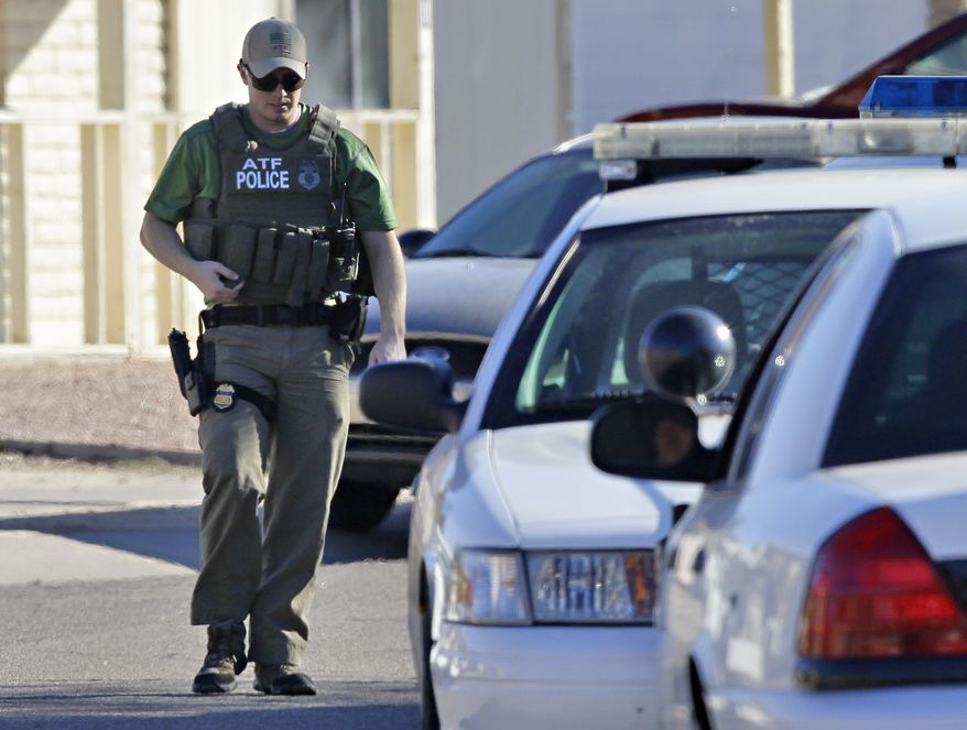 A law enforcement official walks outside of the listed address of a Jared L. Loughner Saturday, Jan. 8, 2011 in Tucson, Ariz. U.S. Rep. Gabrielle Giffords of Arizona was shot in the head Saturday when an assailant opened fire outside a grocery store during a meeting with constituents, killing at least five people and wounding several others in a rampage that rattled the nation. Police say the shooter was in custody, and was identified by people familiar with the investigation as Jared Loughner, 22. Pima County Sheriff's officials said he used a pistol to carry out the shooting spree. U.S. officials who provided his name to the AP spoke on condition of anonymity because they were not authorized to release it publicly. (AP Photo/Matt York)