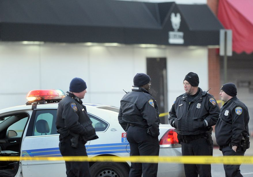 Police stand outside a Baltimore nightclub where an early-morning shooting left a police officer and another man dead on Sunday, Jan. 9, 2011. (AP Photo/Steve Ruark)