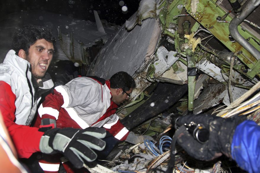 In this picture released by the Mehr news agency, rescue workers attend the scene Sunday after an IranAir Boeing 727 passenger plane crashed as it was making an emergency landing, outside the city of Orumiyeh, 460 miles northwest of Tehran. An IranAir passenger jet carrying 106 people crashed as it was making an emergency landing Sunday in a snowstorm in the country's northwest and broke into several pieces, killing more than 70 of those on board, Iranian media reported. The others survived with light injuries. (Associated Press/Mehr News Agency, Esfandiar Asgharkhani)