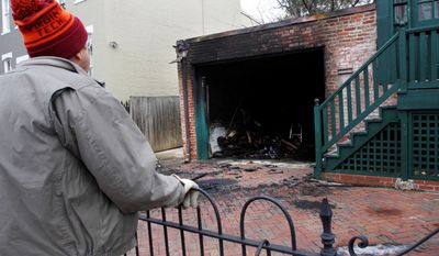 John Fawcett, a neighbor, looks at a charred garage Monday in Southeast Washington where Ashley Turton, the wife of a White House adviser Dan Turton, was found dead inside a burning car. (Associated Press)