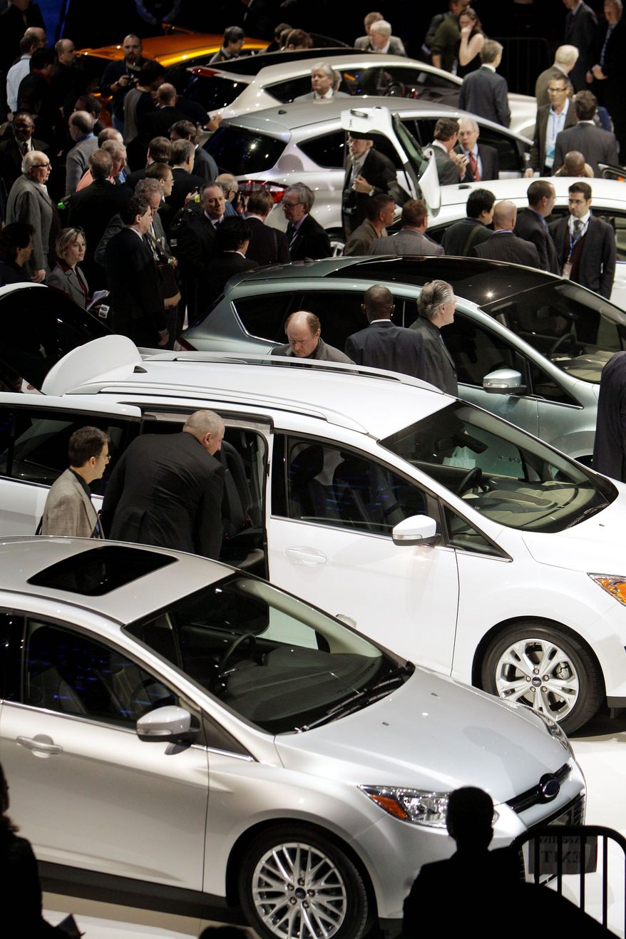 Journalists look over the Ford display Monday at the North American International Auto Show in Detroit, where the latest models debuted. (Associated Press)