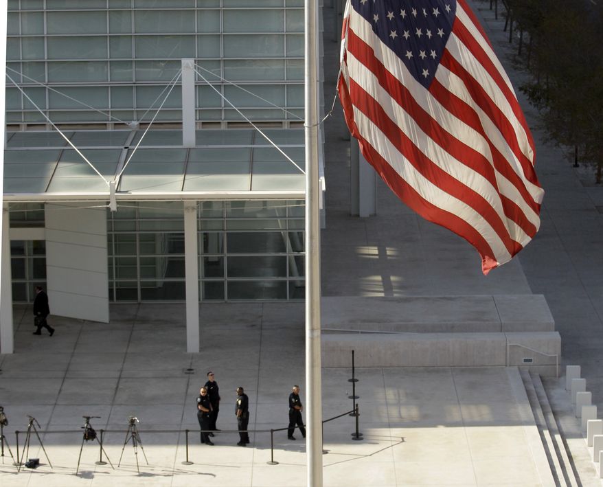 A flag stands at half-staff as security officials stand at the entrance to the the Sandra Day O'Connor United States Courthouse in Phoenix, Ariz., Monday, Jan. 10, 2011, where 22-year-old Jared Loughner is scheduled to appear in federal court on charges he tried to assassinate Rep. Gabrielle Giffords in a shooting rampage that left six people dead. (AP Photo/Charlie Riedel)