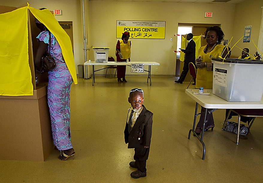 Daniel Chol, 2, looks around as his mother, Josephena Thal, left, of Phoenix, prepares her ballot in a referendum vote on whether South Sudan will become independent from Sudan, at St. James Catholic Church in Glendale, Ariz., on Sunday, Jan. 9, 2011. The polling place in Glendale was one of only eight in the United States. (AP Photo/The Arizona Republic, David Wallace)