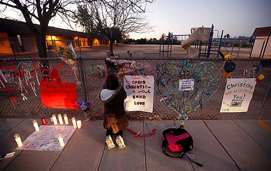 Rachel Cooper-Blackmore, 9, adds a note to a make-shift memorial at Mesa Verde Elementary School in Tucson, Ariz., Monday, Jan. 10, 2011. Christina Green, 9, was shot and killed during an attack at an event for U.S. Rep. Gabrielle Giffords, Arizona Democrat, Saturday. (AP Photo/Chris Carlson)
