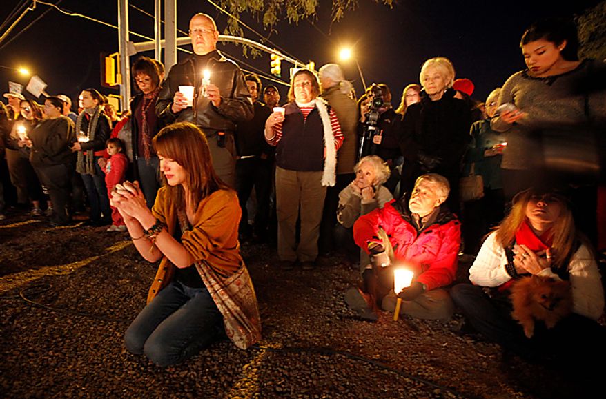 Well-wishers gather for a candle light vigil outside the offices U.S. Rep. Gabrielle Giffords, Arizona Democrat, in Tucson, Ariz., Sunday, Jan. 9, 2011. Mrs. Giffords was critically wounded during a shooting at a political event Saturday, Jan. 8, 2011 in Tucson, Ariz. (AP Photo/Chris Carlson)