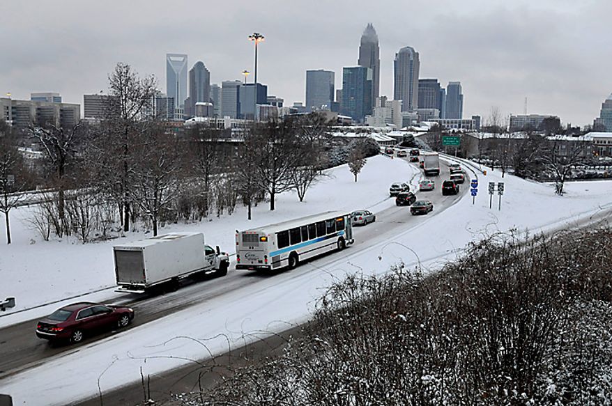 Commuters slowly head toward uptown Charlotte, N.C., early Monday, Jan. 10, 2011, on snow covered roads. Sleet, ice and several inches of snow, as much as 9 inches in some places, blanketed states from Louisiana to the Carolinas mostly unaccustomed to arctic weather and caused at least three deaths and left thousands without power. (AP Photo/Charlotte Observer, Davie Hinshaw )