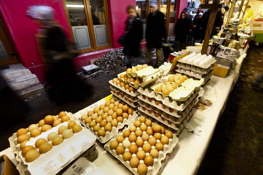 People pass a market stall with eggs at a farmers market in Berlin on Friday, Jan. 7, 2011. German authorities ordered hundreds of pigs slaughtered Tuesday, Jan. 11, 2011, after tests showed high levels of a cancer-causing chemical for the first time in swine, as the nation's dioxin scandal widened beyond poultry and eggs.(AP Photo/Markus Schreiber)