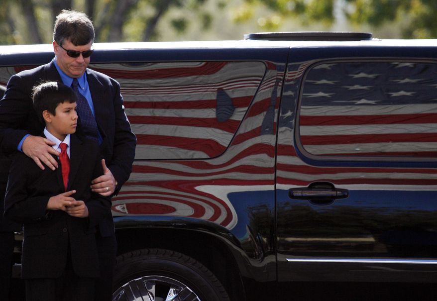 John Green and son Dallas, the respective father and brother of 9-year-old Christina Green, arrive at the St. Elizabeth Ann Seton Church for Christina's funeral on Thursday, Jan. 13, 2011, in Tucson, Ariz. Green was the youngest victim of Saturday's shooting in Tucson. (AP Photo/Mamta Popat, Pool)