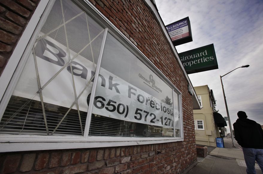 In this Jan. 10, 2011, photo, a man walks past the office of Girouard Properties, which specializes in residential re-sale of single family homes and condominiums/townhomes, in San Mateo, Calif. Lenders are poised to take back more homes this year than any other since the foreclosure crisis started in 2006, says industry tracker RealtyTrac Inc. (AP Photo/Paul Sakuma)