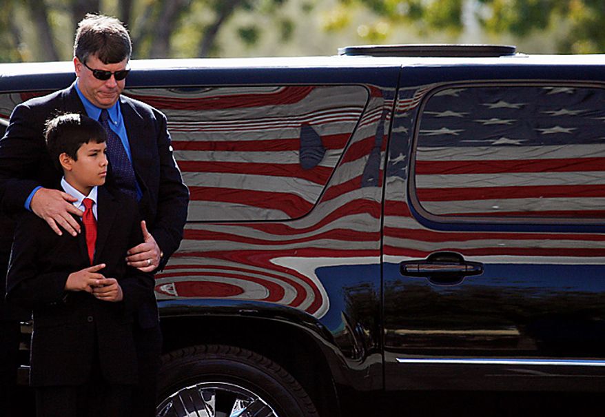 John Green and son Dallas, the respective father and brother of 9-year-old Christina Green, arrive at the St. Elizabeth Ann Seton Church for Christina's funeral on Thursday, Jan. 13, 2011, in Tucson, Ariz. Green was the youngest victim of Saturday's shooting in Tucson. (AP Photo/Mamta Popat, Pool)