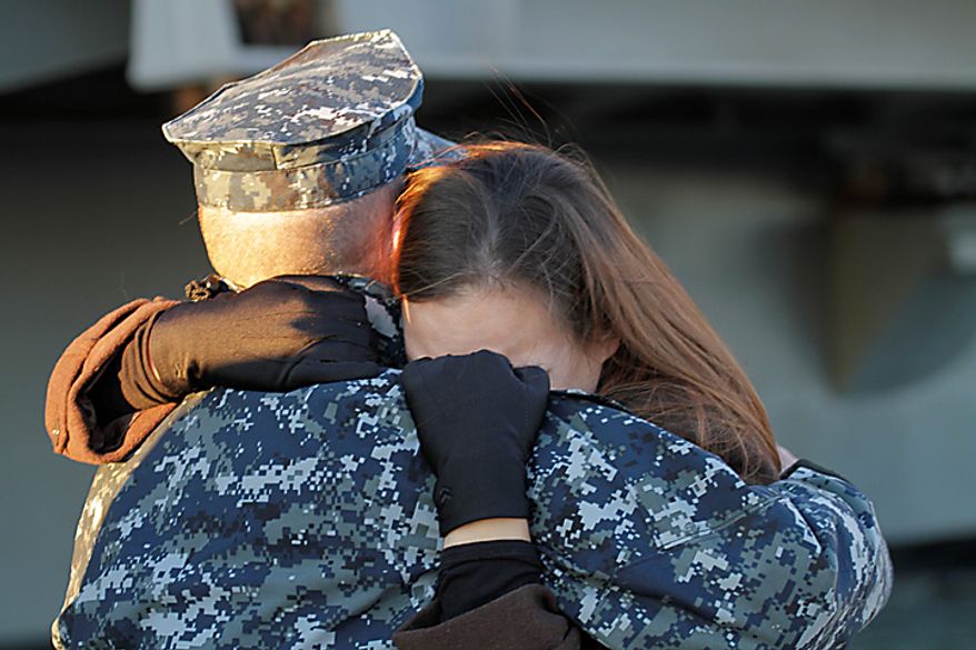 Petty Officer 3rd class, Robert Hampton, of Newport news, Va., gets a good bye hug from his wife, Rebecca, as he prepares to deploy on the nuclear powered aircraft carrier USS Enterprise at Naval Station Norfolk in Norfolk, Va., Thursday, Jan. 13, 2011. The USS Enterprise is deploying without its former commander as Navy brass investigates bawdy, sexually themed videos he showed to thousands of crew members. (AP Photo/Steve Helber)